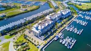 Marina con varios barcos amarrados, rodeada de edificios modernos con un patio central.