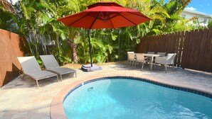 A backyard with a swimming pool, lounge chairs, a table, and an umbrella. - BY THE SEA VACATION VILLAS 4 BED/PRIVATE POOL/ WALK TO EVERYTHING. Amazing location! (Lauderdale-by-the-Sea)