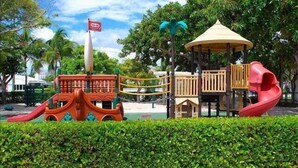 A playground with a slide, climbing structures, and a covered play area. - BY THE SEA VACATION VILLAS 4 BED/PRIVATE POOL/ WALK TO EVERYTHING. Amazing location! (Lauderdale-by-the-Sea)