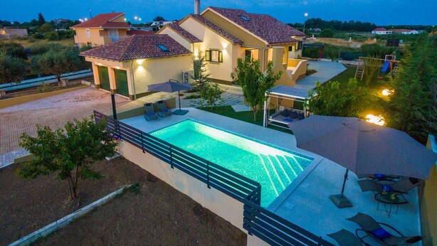 A residential property with a swimming pool, outdoor seating, and a well-maintained garden. - Great Villa Field Hills with sauna and jacuzzi (Poljica-Brig)