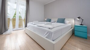 A modern bedroom with a large bed, a nightstand, and a view of a balcony. - Great Villa Field Hills with sauna and jacuzzi (Poljica-Brig)