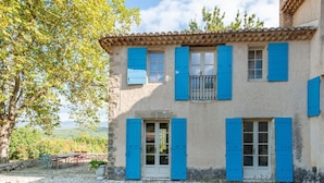A two-story building with blue shutters, a stone facade, and a balcony. - Villa in Saignon with Pool and Scenic Views (Saignon)