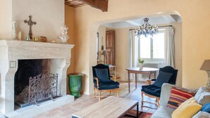 A cozy living room with a fireplace, two armchairs, a sofa, and a dining table. - Villa in Saignon with Pool and Scenic Views (Saignon)