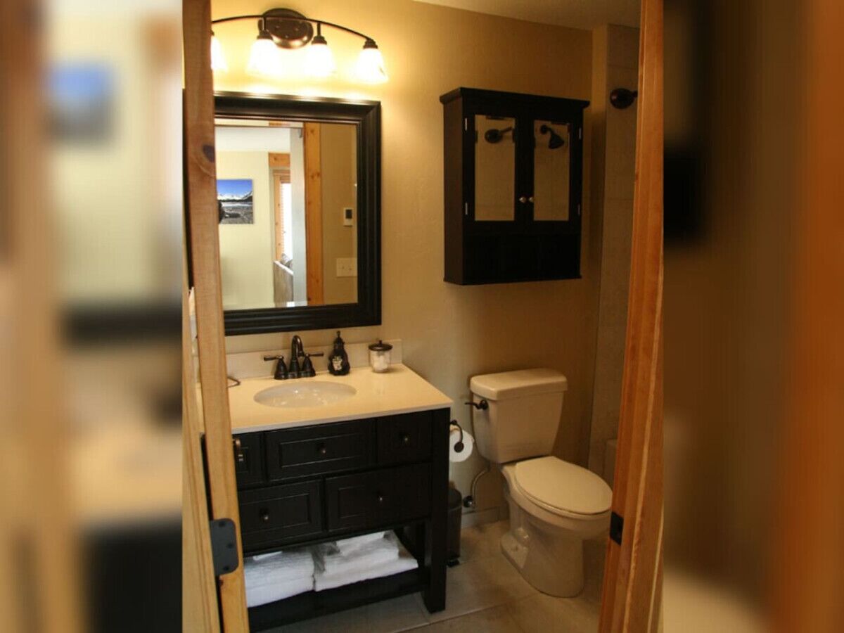 Une salle de bain avec un lavabo, un miroir et des toilettes.