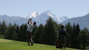A golf course with a mountainous backdrop.
