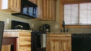 A kitchen with wooden cabinets, a microwave, a stove, and a dishwasher.