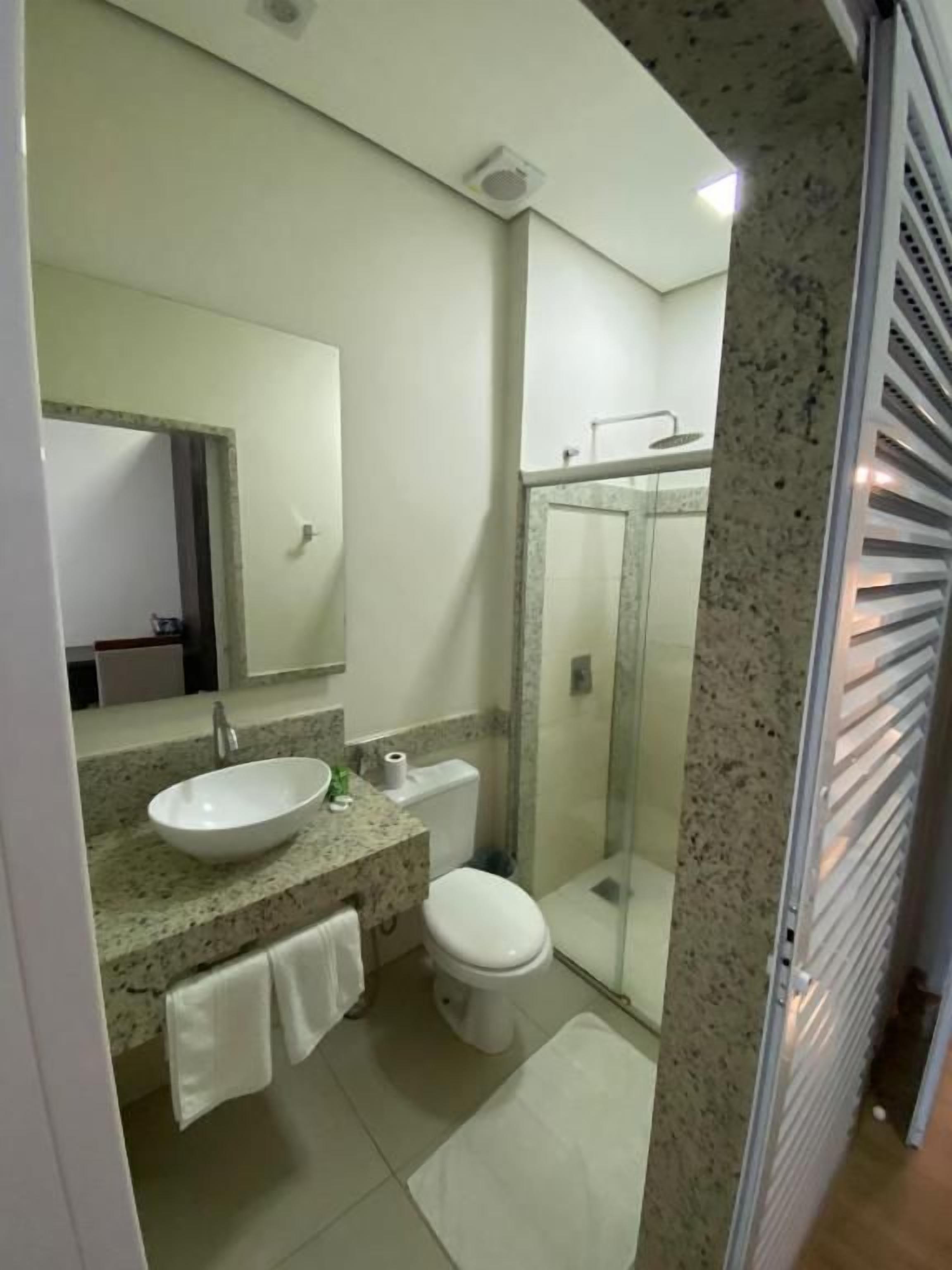 A bathroom with a sink, toilet, and shower.