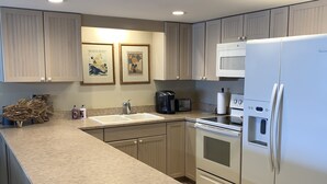 A modern kitchen with a large island, stainless steel appliances, and light wood cabinetry. - Ground floor with King master, 2 twins 2nd bedroom Bunk beds in 3rd bedroom (twins) twin/full combo. (New Smyrna Beach)