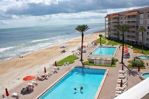 Een resort met een zwembad, toegang tot het strand en uitzicht op de oceaan.