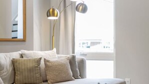 A modern living room with a sectional sofa, a round coffee table with a plant, and a floor lamp.