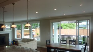 Eine geräumige Küche mit einer großen Kochinsel, ein Essbereich mit Tisch und Stühlen sowie eine Glastür zum Patio.