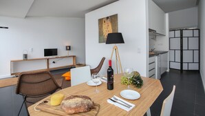 Een moderne keuken met een eethoek, een houten tafel gedekt voor een maaltijd, en een schilderij aan de muur.