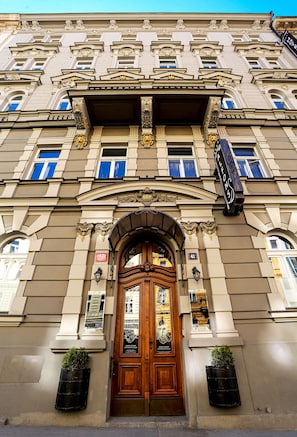 A historic building with ornate architectural details, a prominent entrance, and a sign indicating the address. - Alfons Boutique Hotel (Prague)