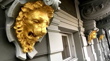 A building facade with ornate gold lion heads and classical architectural details.