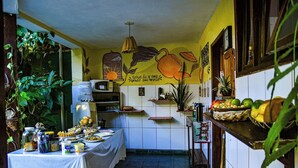 Una cocina con una mesa lista para comer, un microondas y varios utensilios de cocina.