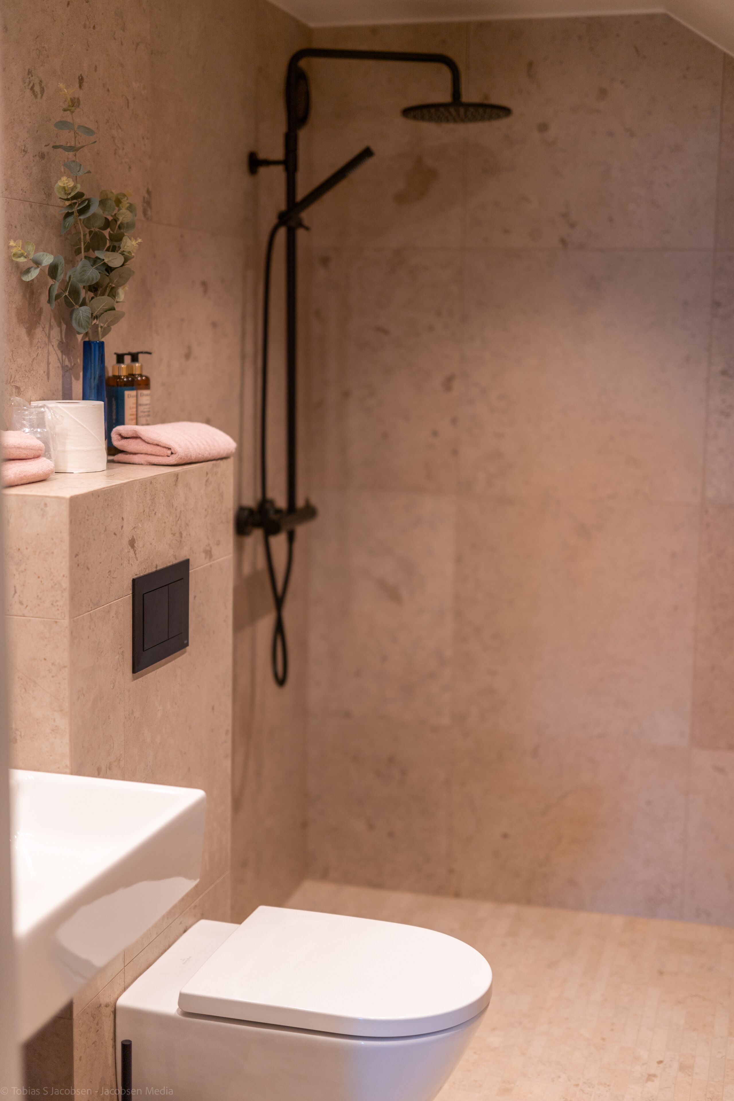 A modern bathroom with a shower, toilet, and sink.