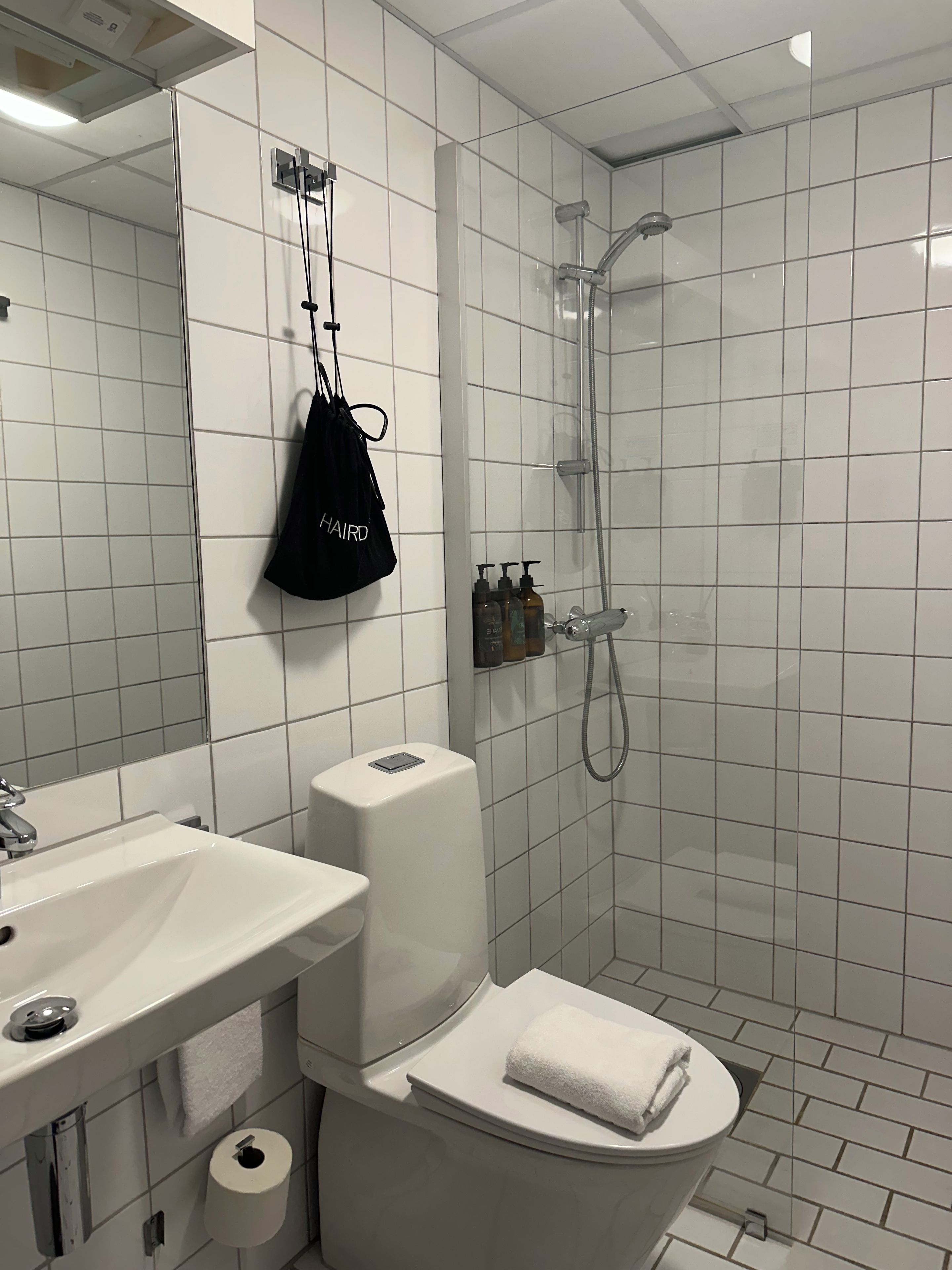 A modern bathroom with a toilet, sink, and shower.
