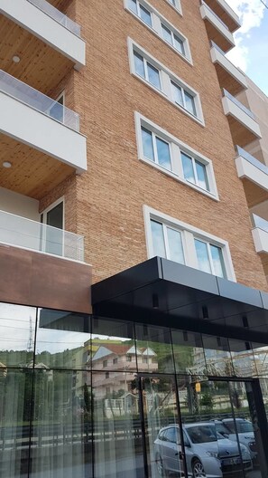 A multi-story building with a brick facade, large windows, and balconies. - Blue Marine Hotel  (Rrashbull)