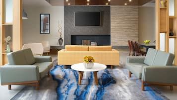 Una sala de estar moderna con un sofá, dos sillones, una mesa de centro y una chimenea.