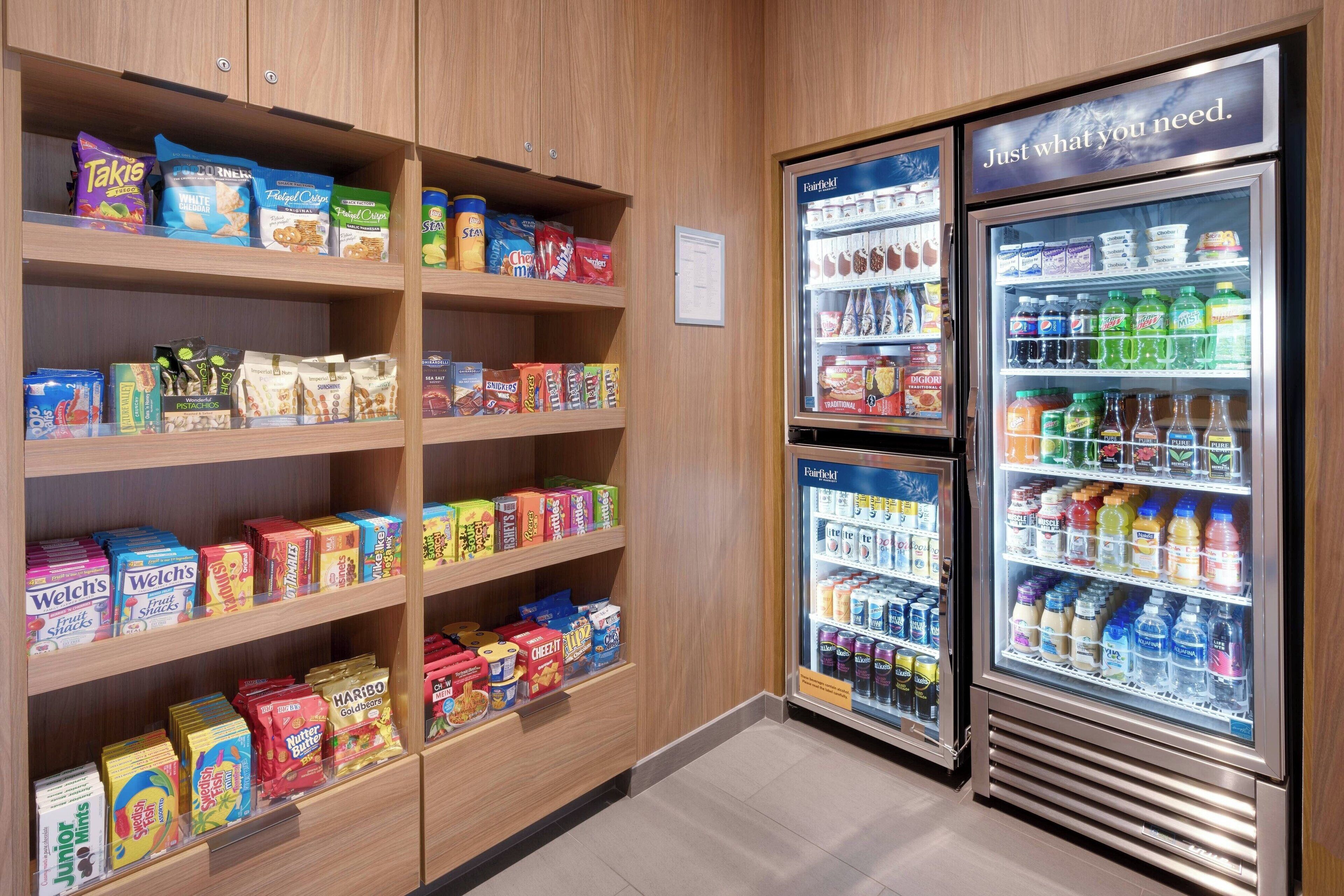 A snack and beverage section with shelves stocked with various snacks and a refrigerated display case with drinks.