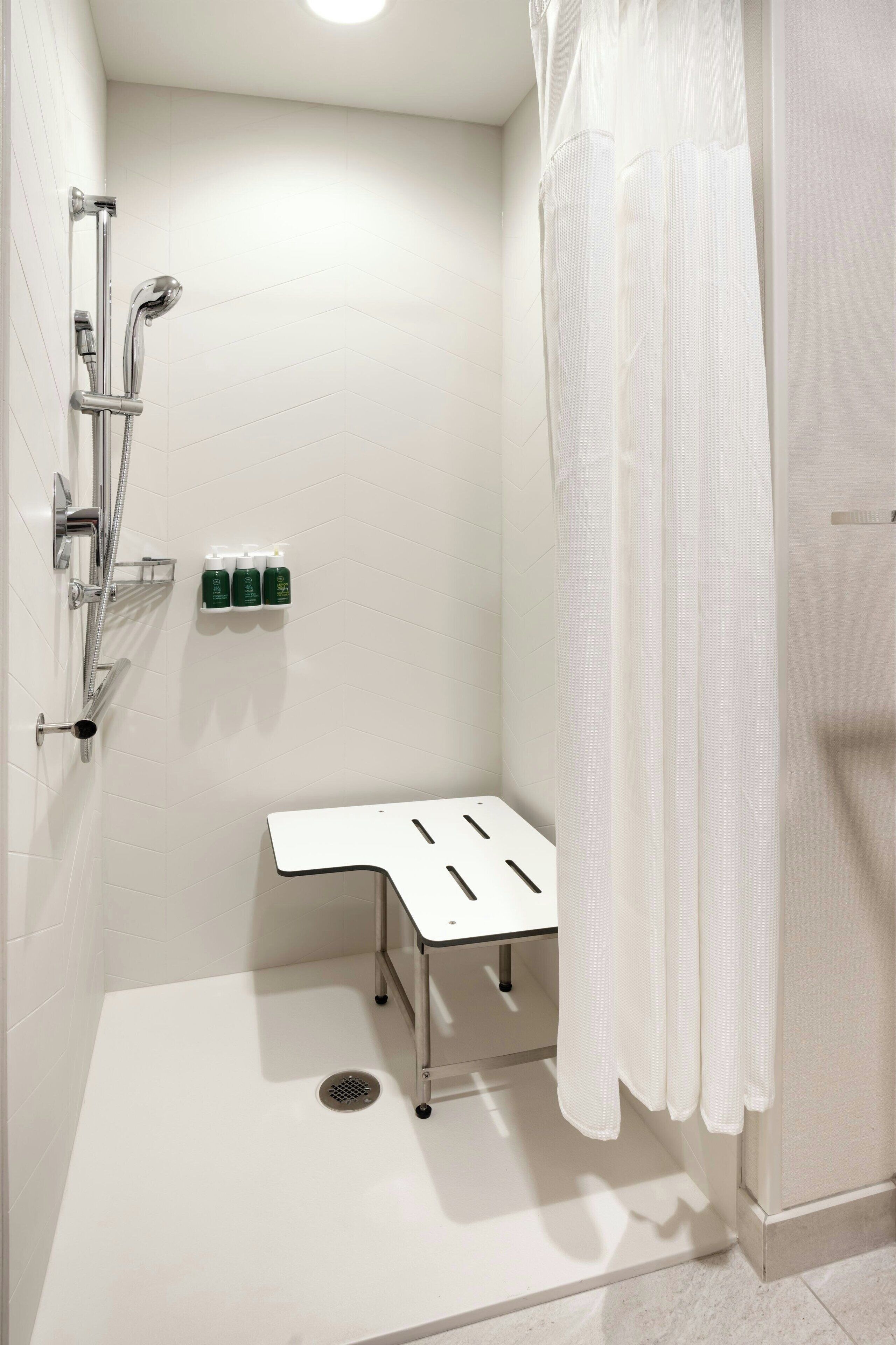 Un baño moderno con ducha, lavamanos e inodoro.