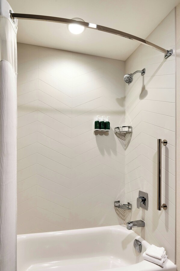 A modern bathroom with a freestanding bathtub, a showerhead, and a towel rack.
