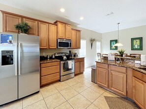 A kitchen with wooden cabinets, stainless steel appliances, and a granite countertop.