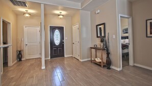 A spacious hallway with hardwood floors, white doors, and a decorative door with a stained glass design. - La Cueva~fantastic 3 Bedroom Home. Sleeps 6-8 People. Near Carlsbad Caverns (Carlsbad)