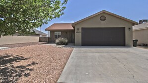 A single-story house with a garage, a well-maintained driveway, and a small garden area. - La Cueva~fantastic 3 Bedroom Home. Sleeps 6-8 People. Near Carlsbad Caverns (Carlsbad)