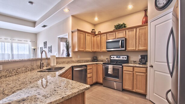 A modern kitchen with granite countertops, stainless steel appliances, wooden cabinets, and a large island. - La Cueva~fantastic 3 Bedroom Home. Sleeps 6-8 People. Near Carlsbad Caverns (Carlsbad)