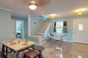 A dining area with a table and chairs, a staircase, and a door.