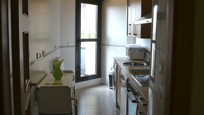 Una cocina compacta con comedor, una ventana y una puerta que da al exterior.