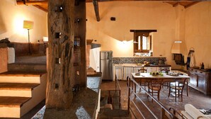 Eine rustikale Küche mit einer Holztreppe, einem Essbereich und einem Kühlschrank.