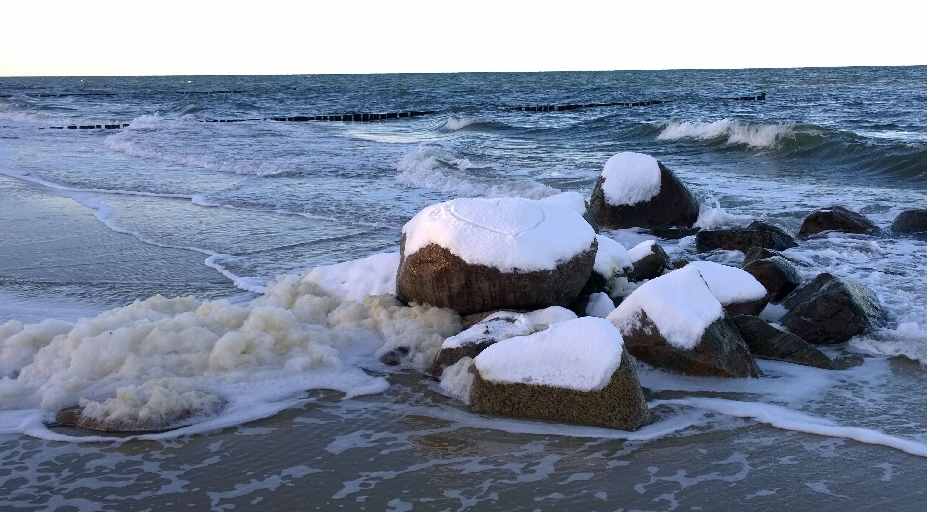 Una costa rocosa con olas rompiendo contra las rocas.