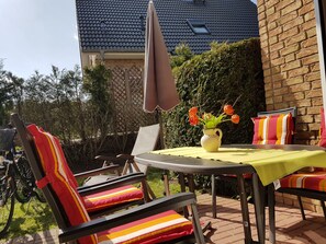 An outdoor patio with a table, chairs, and a potted plant. - Comfortable apartment for four people. Smart TV and WLAN included. (Ostseebad Boltenhagen)
