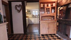 A kitchen with a checkered floor, wooden cabinets, and a heart-shaped decoration on the wall. - Idyllic half-timbered house with a large garden and playground and orchard (Cleebourg)