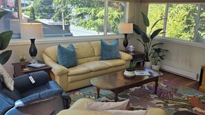 A living room with a sofa, armchair, coffee table, and a television. - The Suite Spot is a lovely two bedroom suite in a quiet neighborhood (Victoria)