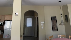 Uma casa de dois andares com varanda, cozinha, sala de jantar e corredor que dá para uma porta.