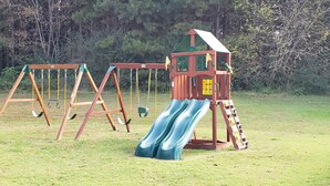 Une aire de jeux avec des balançoires et un toboggan.