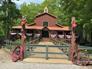 A rustic building with a wooden exterior and a porch, surrounded by trees.
