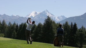 Un campo de golf con montañas al fondo.