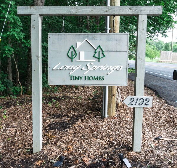 A sign for Tiny Homes at Long Springs, featuring a house icon and the address 2192.
