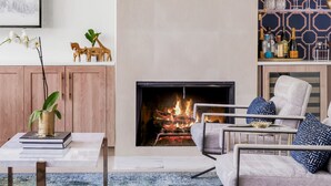 Ein modernes Wohnzimmer mit Kamin, Sitzgruppe und Dekorationselementen.