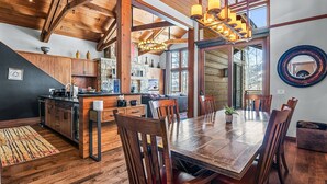 Una cocina amplia con vigas de madera, una mesa de comedor grande y una chimenea de piedra.