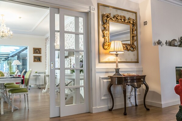 A room with a dining area, a large mirror, and a lamp on a table. - Solar Sampaio E Melo (Trancoso)