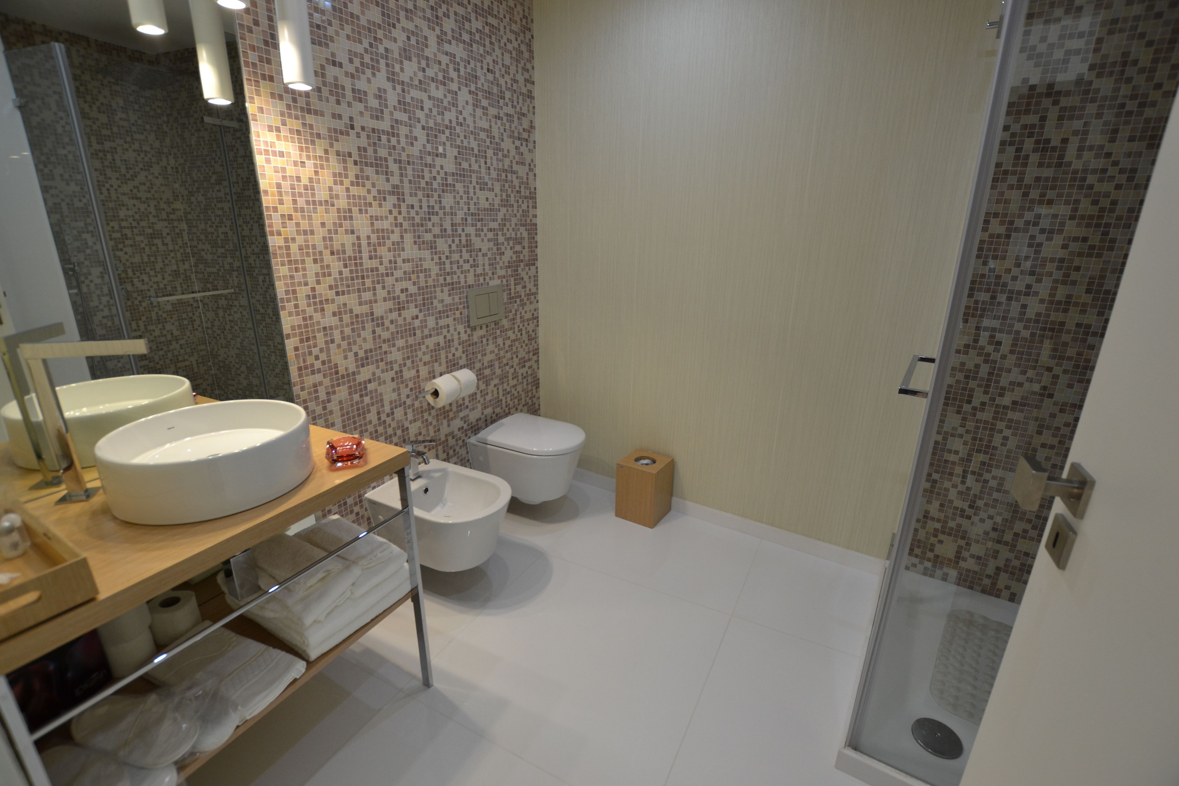 Un baño moderno con un lavamanos grande, inodoro y zona de ducha.