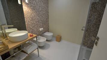 Un baño moderno con un lavamanos grande, inodoro y zona de ducha.