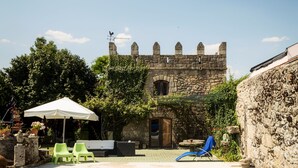 Una piscina con sillones de descanso y una estructura similar a un castillo al fondo.