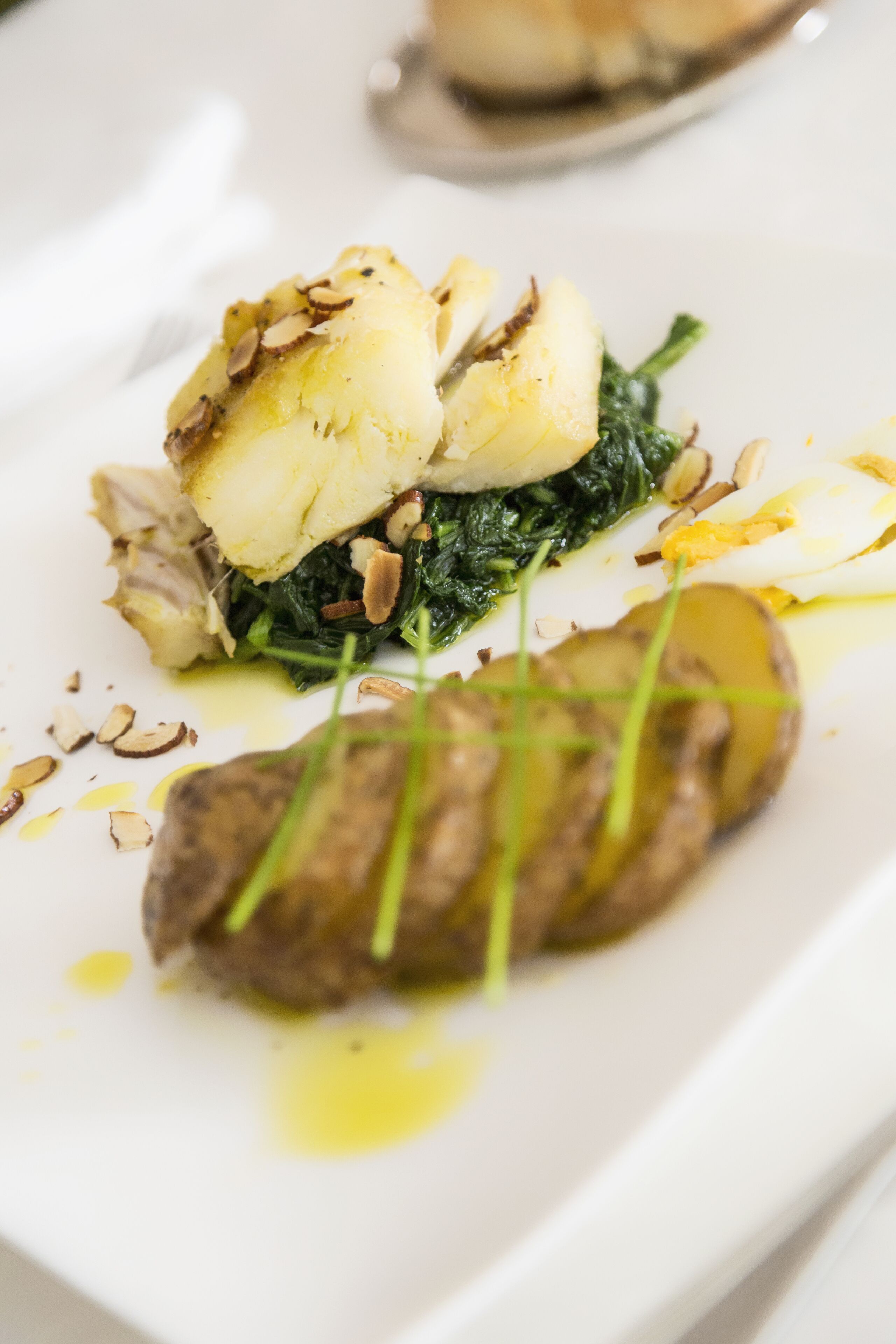 Ein angerichtetes Gericht mit Fleisch, Kartoffeln und Gemüse.
