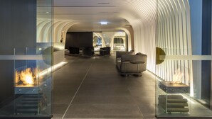 A modern hotel lobby with a glass railing, seating area, and a fireplace. - SKYE Suites Sydney (Sydney)